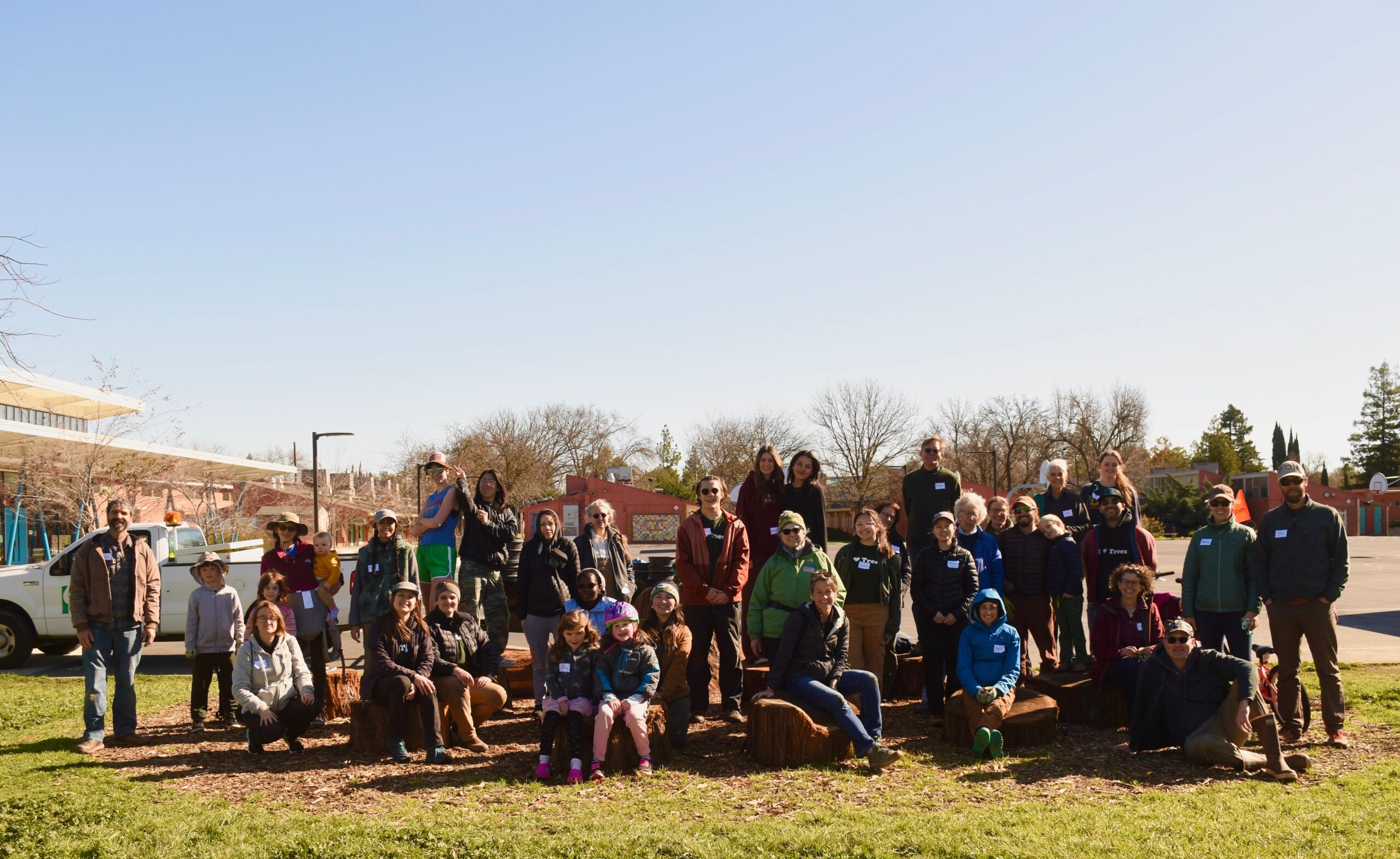 Volunteers pose for a group photo at a planting event on an Elementary School campus.