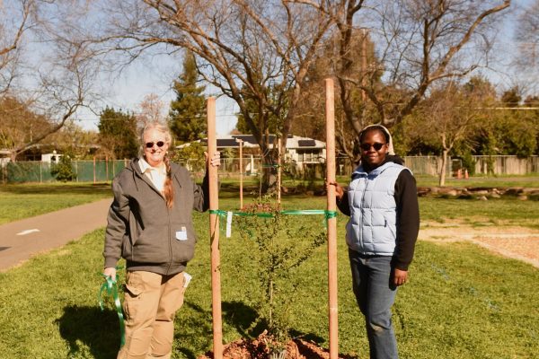 Two Green Volunteers pose with newly planted tree.