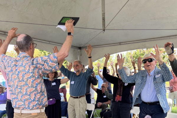 Community members rejoice in a tree cheer at the Legacy Event in 2023.